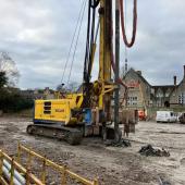 A yellow drilling rig on a constreuction site