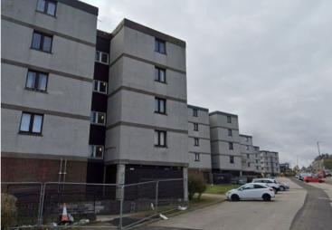A row of mid-rise, grey, flats 