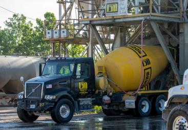A blue and yellow concrete mixer truck