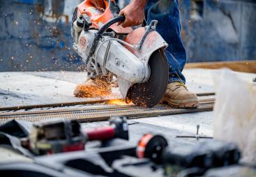 a close up of a circular saw cutting concrete