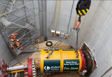 A yellow TBM being lowered into a launch pit