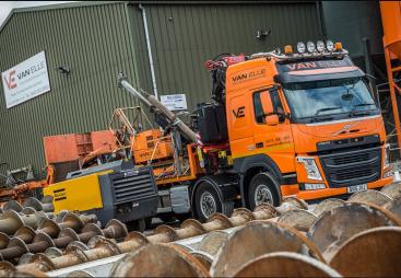 An orange HGV carrying an orange piling rig