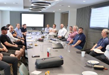 A group of men sitting round a board table