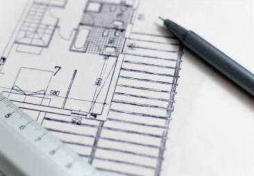 A black pen and a plan of a house with a white ruler