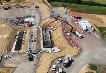 An aerial photo of a construction site with a red concrete pump