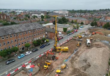 An aerial view of a housing development under construction with a yellow piling rig and other assorted plant.