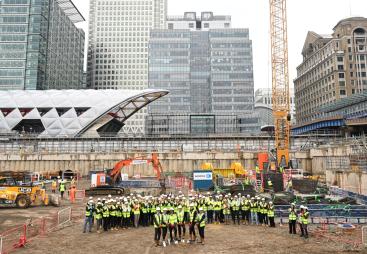A large group of people wearing PPE in an urban construction site