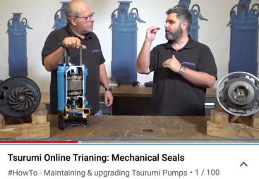 A bald headed man and a man with a beard behind a bench with a blue pump