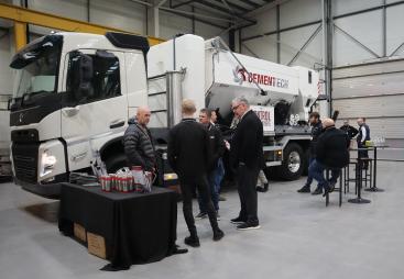 A group of men socialize in front of a volumetric concrete mixer at Volumetric's first Christmas open day was held at its new facility in Wednesbury, in the West Midlands. 