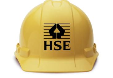 A yellow hard hat with the HSE logo in black on its front