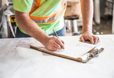 A construction worker looking at plans