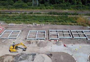 An aerial view of a construction site showing the foundations of several houses under construction.