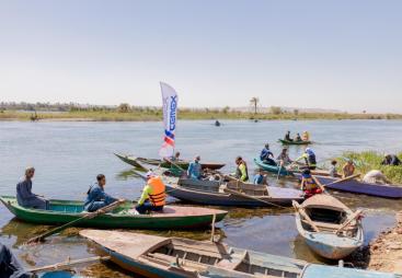People in small boats help clear the River Nile as part of the VeryNile environmental initiative