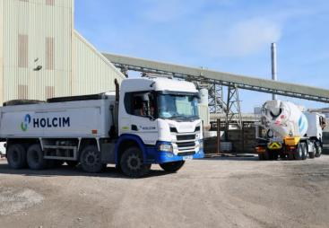 A white, Holcim branded truck at a cement works.