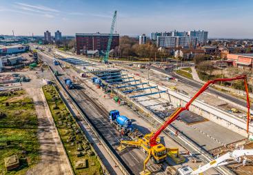An aerial view of Ashcourt Concrete's 1,200m³ concrete pour for the A63 underpass project in Hull, showing a blue crawler crane and a yellow and red concrete pump.