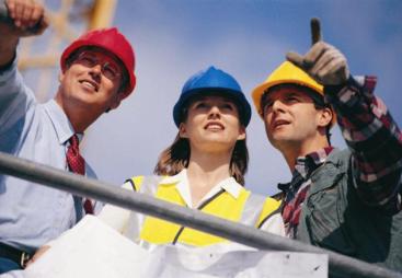 Three people in PPE. One in a red hard hat, one in blue and one in yellow.