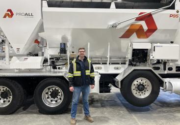 Derrick Murias, the new General Manager at ProAll, stand in front of a ProAll mixer.