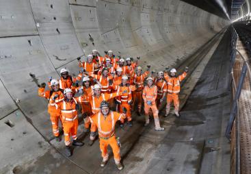 A group of construction workers gather in a tunnel to celebrate the completion of a 5 mile long tunnel under London as part of HS2