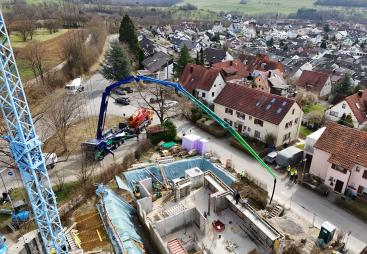 An aerial view of the new Volvo Trucks and Putzmeister fully electric alternative for pumping concrete in action on a construction site. 