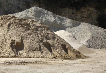 Two piles of aggregate on a quarry floor
