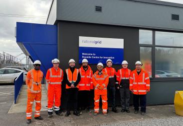 The Hyperion Robotics and National Grid teams, all in orange PPE, stand outside the Deeside Centre for Innovation, National Grid’s advanced testing facility in North Wales.