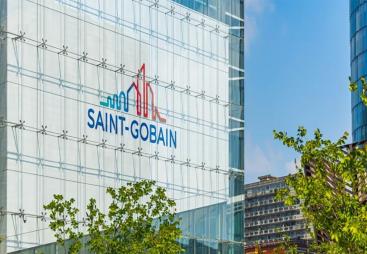 The blue and red Saint-Gobain logo on the side of a glass paneled, high-rise building.