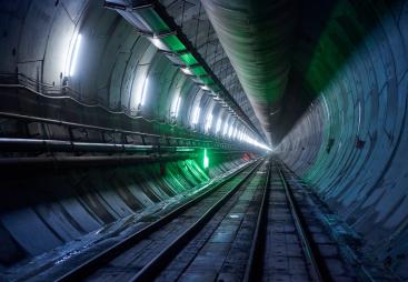 A diimly lit, concrete lined tunnel, Part of the newly completed westbound tunnel on the Italian side of the Brenner Base Tunnel. Over 400,000 precast segments will be used in total. (Image: Webuild)