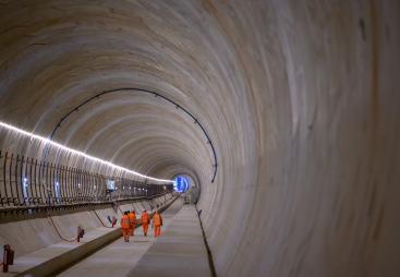 The inside of Long Itchington Wood Tunnel, a 1.6 km twin-bore tunnel built as part of the HS2 high-speed rail line in Warwickshire. Constructed using a tunnel boring machine (TBM), it was designed to protect the ancient woodland above, reducing environmental impact. The concrete-lined tunnel plays a key role in HS2’s central section, forming part of the route between London and Birmingham.