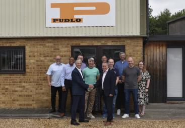 Malcolm Thornton and Scott Wilson (shaking hands) pictured with the PUDLO team outside their office following the deal to buy the company.