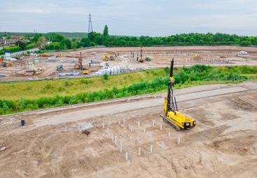 A yellow foundation rig prepares to start work at a large housing project in St Helens.