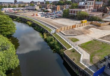An aerial view of the completed riverside walkway in Rotherham links Water Lane to the town centre, supported by new sheet piling and concrete capping beams.