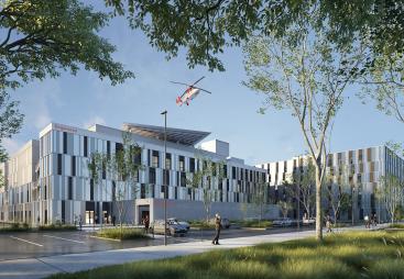 A red helicopter flies over the new Caen University Hospital, which features 110,000 m² of healthcare space built using lower-carbon concrete. Photo Credit: ©CHU de Caen Normandie