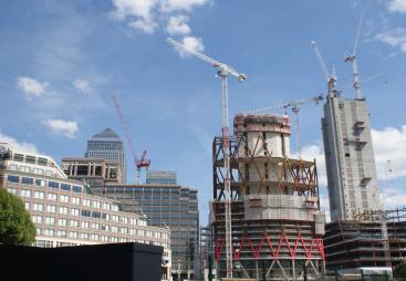 High rise buildings under construction with a tower crane and 1 Canada Wharf in the background