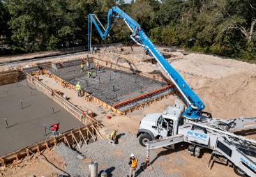 A concrete pump places concrete during construction of foundations