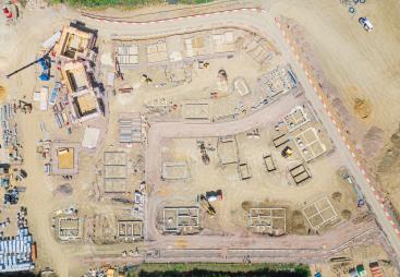 A drone shot of a new housing estate under construction showing the foundations of the new houses