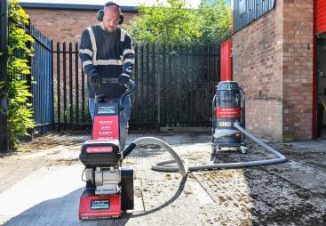 A man with beard using one of Trelawny’s new VoltMax range, which includes a grinder, scarifier and stripper – all powered by 82V lithium-ion batteries, prepares a surface for construction work