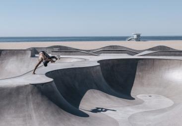 2024/25 Concrete in Life Winner, Venice Beach Skating by Henrik Hagerup shows a single skateboarder performing tricks at a concrete skatepark with the sea and beach in the background
