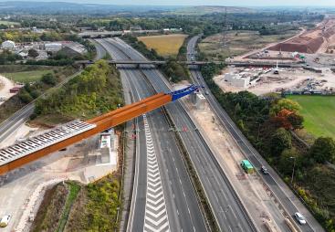 An aerial view of The HS2 viaduct East Deck being slid into place over the M6, supported by four pairs of reinforced concrete piers.