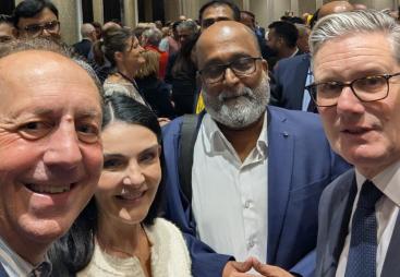 Four people look into the camera to take a selfie