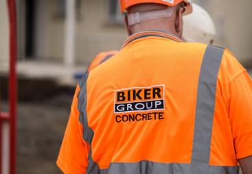 A construction worker in Biker Group branded orange PPE and hard hat