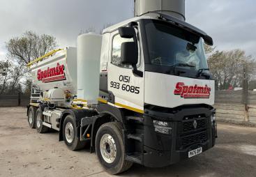 A white screed truck with red decals