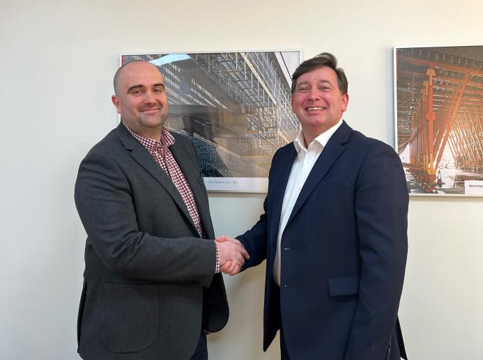 Two men shaking hads in a badly lit and composed photo