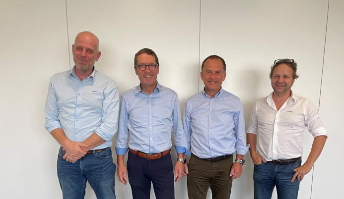 Four men standing in a line
