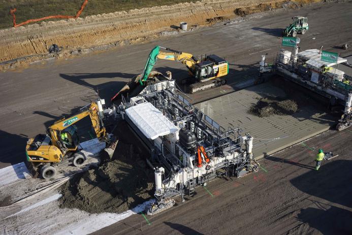 An aerial view of some men and machines repairing a concrete road