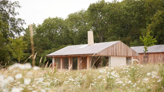 A small single storey house on the edge of a wood