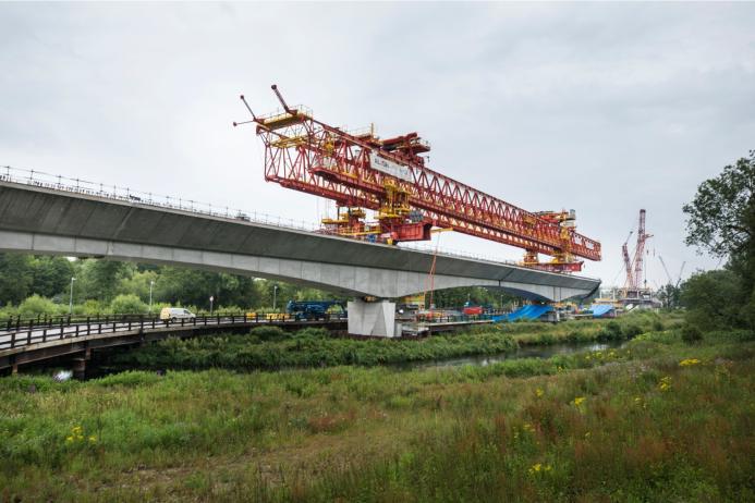 A picture of an orange launching girder sitting on top of an under construction railway viaduct