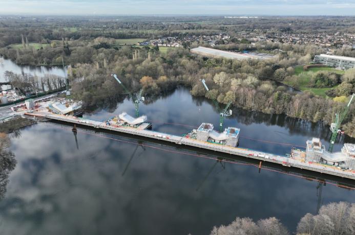 An aerial picture of an under construction railway viaduct across a lake