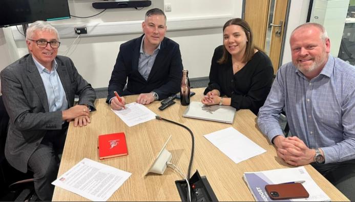 Three men and a woman sitting around a wooden table