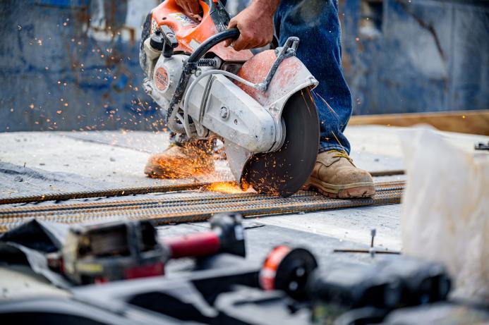 a close up of a circular saw cutting concrete