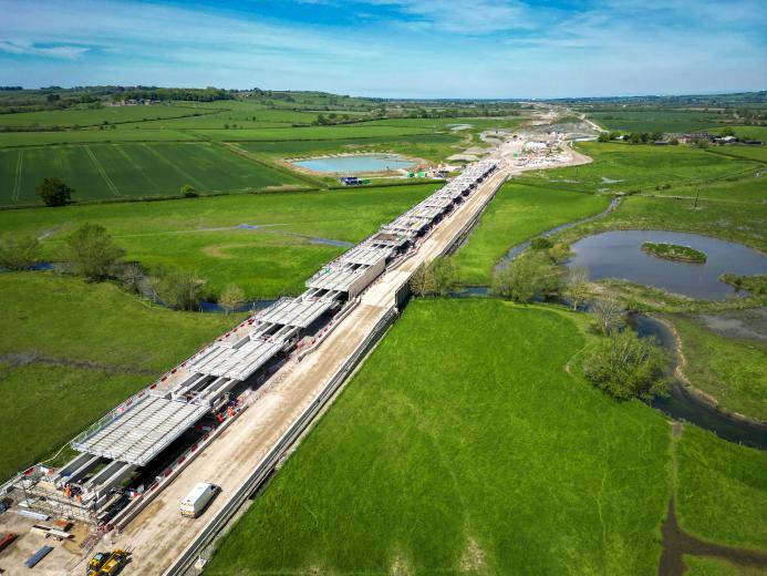 Aerial view of a Viaduct under construction surrounded by green fields